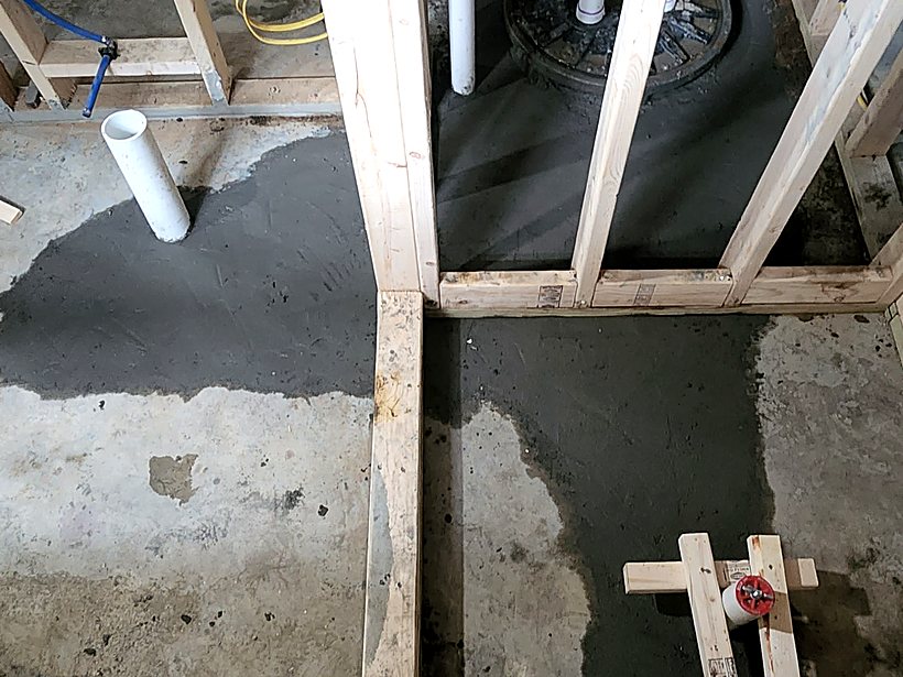 Concrete basement slab broken open to run drain lines for a new basement bathroom