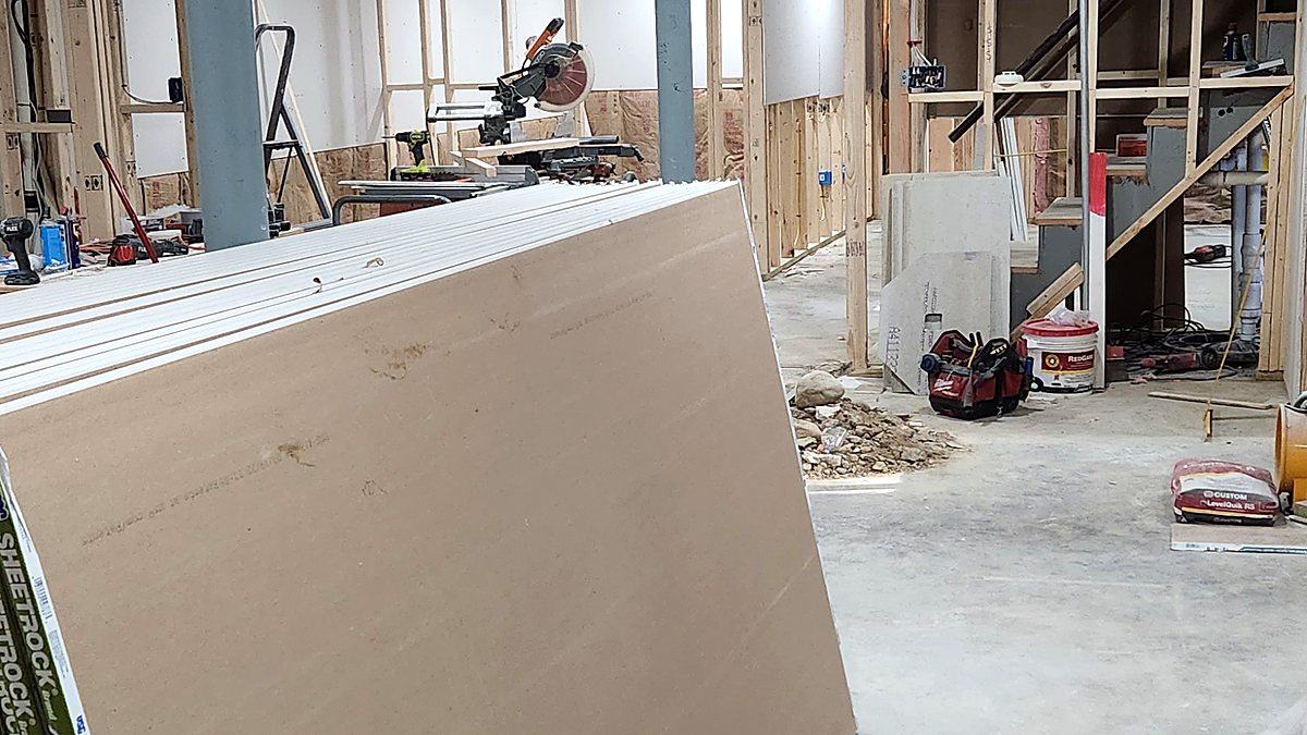 Drywall sheets delivered into a framed basement, ready to be hung
