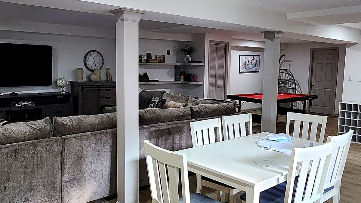 Finished basement with a dining table, sectional sofa, wall-mounted television and pool table