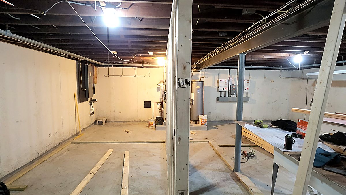 Basement framing under way, with new stud walls built around existing steel support columns