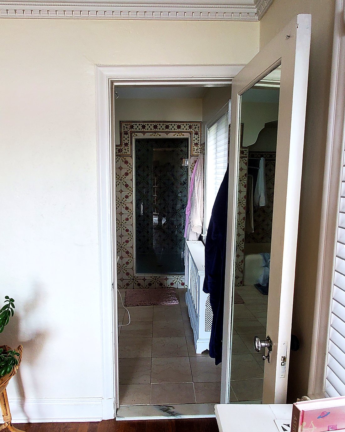 Dated master bathroom seen from the bedroom doorway before remodeling