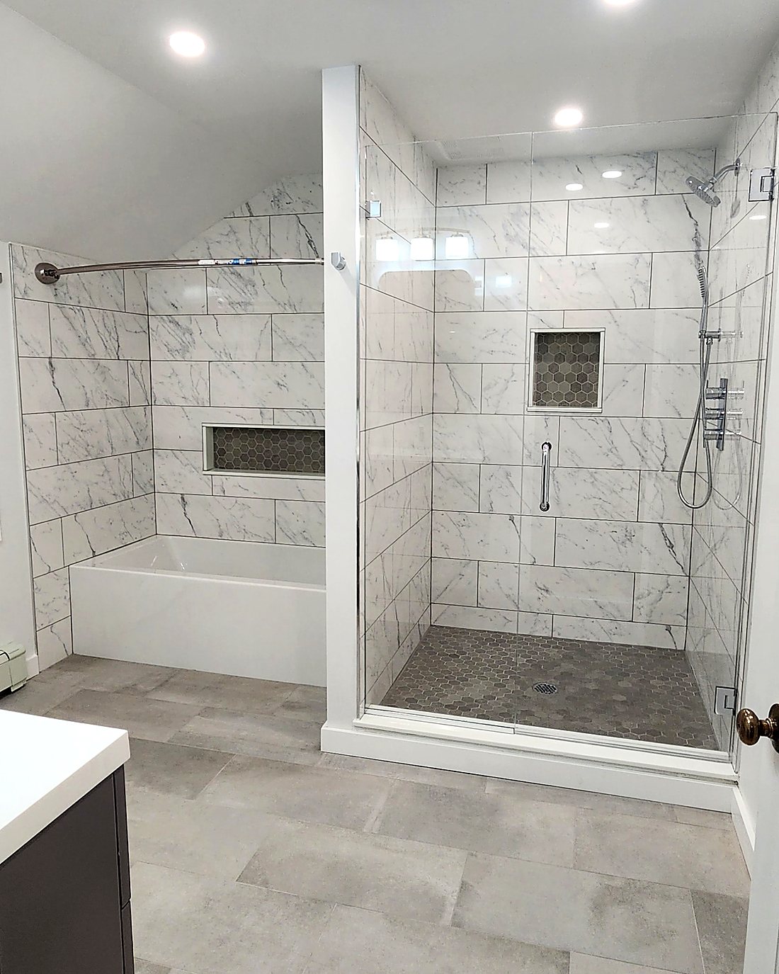 Finished Mid-City Stamford bathroom showing the walk-in shower and separate tub in marble-look porcelain